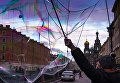 Уличный артист надувает мыльные пузыри на набережной канала Грибоедова в Санкт-Петербурге Уличный артист надувает мыльные пузыри на набережной канала Грибоедова в Санкт-Петербурге