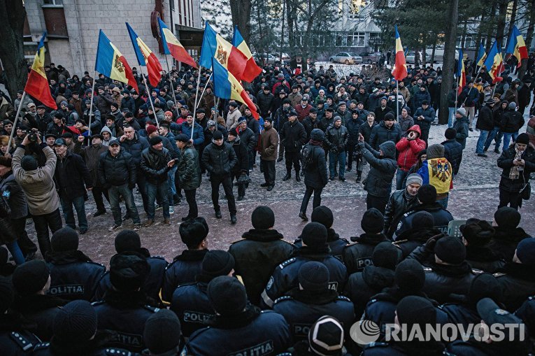 Протестующие и сотрудники правоохранительных органов у здания парламента в Кишиневе Протестующие и сотрудники правоохранительных органов у здания парламента в Кишиневе