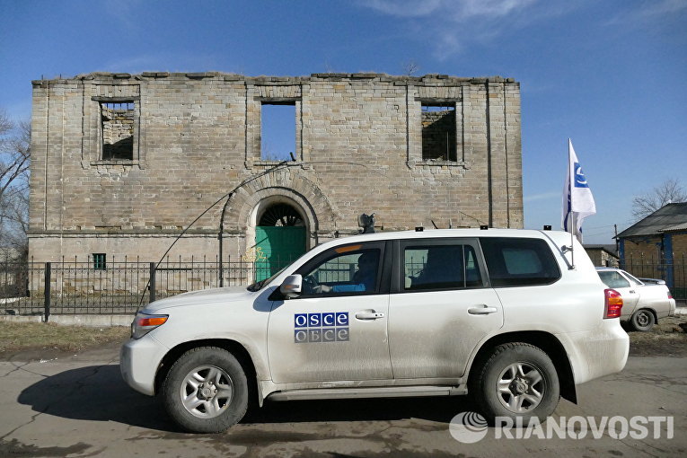 Автомобиль ОБСЕ у разрушенного дома в поселке Зайцево в Донецкой области Автомобиль ОБСЕ у разрушенного дома в поселке Зайцево в Донецкой области