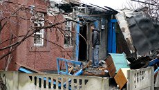 Мужчина у дома, поврежденного в результате обстрела украинскими силовиками. Архивное фото Мужчина у дома, поврежденного в результате обстрела украинскими силовиками. Архивное фото
