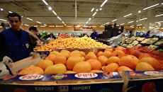 The seller at the counter with tangerines from Turkey.  Archival photo