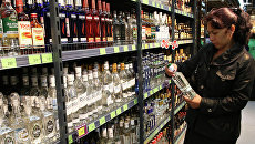 Покупательница в отделе алкогольной продукции в магазине. Архивное фото Покупательница в отделе алкогольной продукции в магазине. Архивное фото
