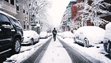 Мужчина на заснеженной улице. Архивное фото Мужчина на заснеженной улице. Архивное фото