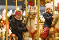 Дети на карусели во время открытия старейшей Рождественской ярмарки Штрицельмаркт в Дрездене Дети на карусели во время открытия старейшей Рождественской ярмарки Штрицельмаркт в Дрездене