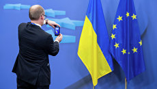 Человек фотографирует флаги Украины и Евросоюза Человек фотографирует флаги Украины и Евросоюза
