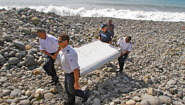 Полицейские несут обломки самолета, найденные в Сен-Андре, Реюньон. Архивное фото