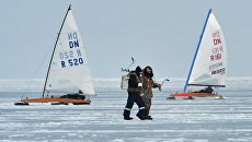 Рыбаки (на первом плане) и участники открытых соревнований по буерному спорту на кубок командующего Тихоокеанским флотом на льду Амурского залива во Владивостоке Рыбаки (на первом плане) и участники открытых соревнований по буерному спорту на кубок командующего Тихоокеанским флотом на льду Амурского залива во Владивостоке