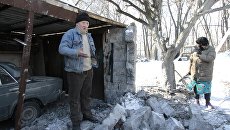 Местные жители возле гаража, пострадавшего в результате обстрела украинскими силовиками, в городе Макеевка Донецкой области. Архивное фото Местные жители возле гаража, пострадавшего в результате обстрела украинскими силовиками, в городе Макеевка Донецкой области. Архивное фото