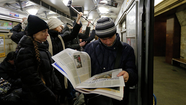 Молодой человек читает газету в Киевском метро. Архивное фото