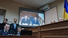 Бывший президент Украины Виктор Янукович во время видеотрансляции на экране монитора в Святошинском районном суде Киева Бывший президент Украины Виктор Янукович во время видеотрансляции на экране монитора в Святошинском районном суде Киева