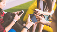 Young people with smartphones.  Archival photo