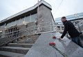 Мужчина возлагает цветы у входа в вестибюль станции метро Сенная площадь в Санкт-Петербурге Мужчина возлагает цветы у входа в вестибюль станции метро Сенная площадь в Санкт-Петербурге