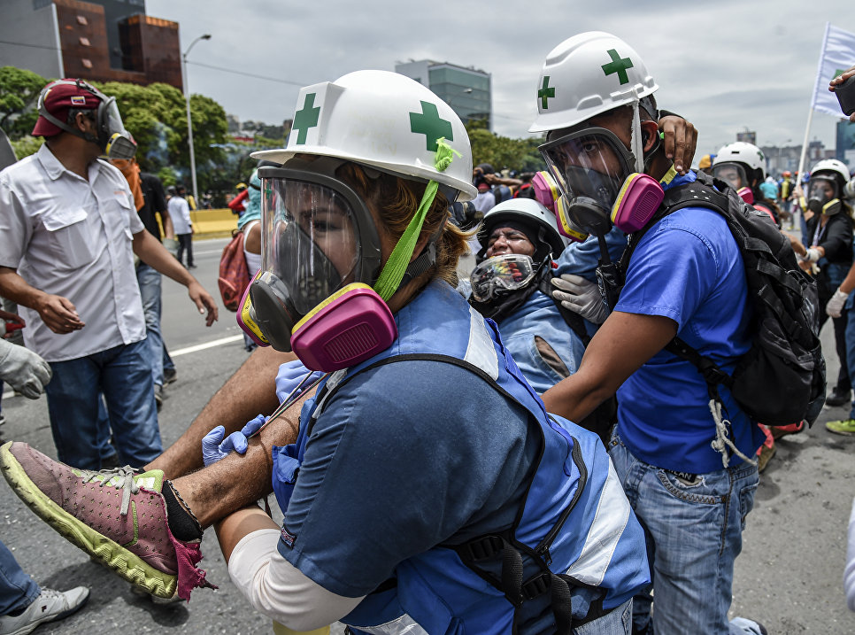 Раненый оппозиционный демонстрант во время акции протеста против президента Венесуэлы Николаса Мадуро в Каракасе. Венесуэла, 3 мая 2017