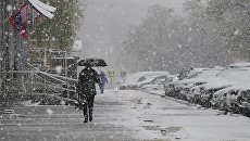 Прохожие во время снегопада на Ленинском проспекте в Москве. Архивное фото Прохожие во время снегопада на Ленинском проспекте в Москве. Архивное фото