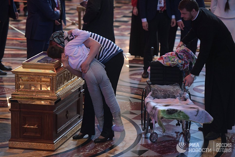 Женщина прикладывает ребенка к ковчегу с мощами святителя Николая Чудотворца в храме Христа Спасителя в Москве