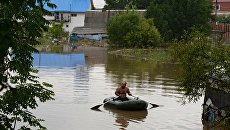 Мужчина на лодке во время наводнения в Уссурийске. Архивное фото Мужчина на лодке во время наводнения в Уссурийске. Архивное фото