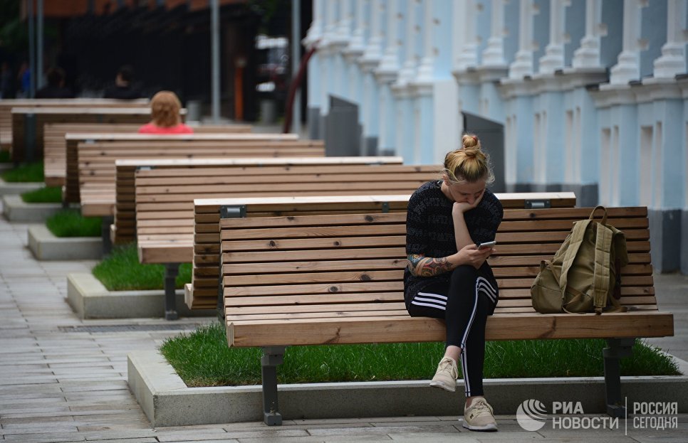 Девушка сидит на скамейке в 3-м Голутвинском переулке в Москве Девушка сидит на скамейке в 3-м Голутвинском переулке в Москве
