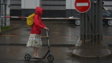 Девушка на самокате во время дождя в Москве Девушка на самокате во время дождя в Москве