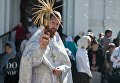 Священнослужитель окропляет святой водой яблоки и фрукты во время богослужения в честь праздника Преображения Господня у собора Воздвижения Креста Господня в Омске. 19 августа 2017 Священнослужитель окропляет святой водой яблоки и фрукты во время богослужения в честь праздника Преображения Господня у собора Воздвижения Креста Господня в Омске. 19 августа 2017