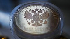 Герб РФ на монете. Архивное фото Герб РФ на монете. Архивное фото