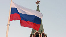Российский государственный флаг на фоне кремлевской башни. Архивное фото Российский государственный флаг на фоне кремлевской башни. Архивное фото