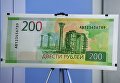 Образец банкноты номиналом 200 рублей на презентации новых банкнот Банка России Образец банкноты номиналом 200 рублей на презентации новых банкнот Банка России