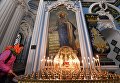 Прихожанка ставит поминальную свечку в Воскресенском соборе на территории Ново-Иерусалимского мужского монастыря Прихожанка ставит поминальную свечку в Воскресенском соборе на территории Ново-Иерусалимского мужского монастыря
