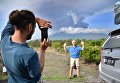Туристы фотографируются на фоне извержения вулкана Агунг на острове Бали в Индонезии Туристы фотографируются на фоне извержения вулкана Агунг на острове Бали в Индонезии