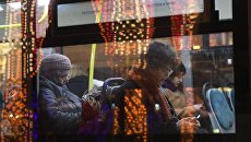 Пассажиры в салоне автобуса, проезжающего мимо Театральной площади в Москве. Архивное фото Пассажиры в салоне автобуса, проезжающего мимо Театральной площади в Москве. Архивное фото
