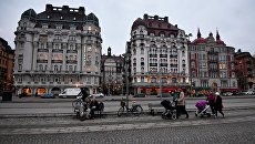 Люди на набережной в Старом городе Стокгольма. Архивное фото Люди на набережной в Старом городе Стокгольма. Архивное фото