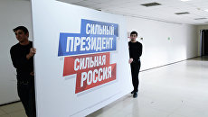 Рабочие несут плакат в избирательный штаб действующего президента РФ Владимира Путина. Архивное фото Рабочие несут плакат в избирательный штаб действующего президента РФ Владимира Путина. Архивное фото