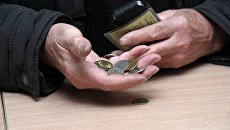 Мужчина держит монеты в руке Мужчина держит монеты в руке