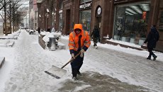 Сотрудник коммунальных служб убирают последствия снегопада на Тверской улице в Москве. Архивное фото Сотрудник коммунальных служб убирают последствия снегопада на Тверской улице в Москве. Архивное фото