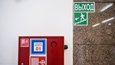 Пожарный шкаф и указатель направления эвакуации при пожаре в торговом центре. Архивное фото Пожарный шкаф и указатель направления эвакуации при пожаре в торговом центре. Архивное фото