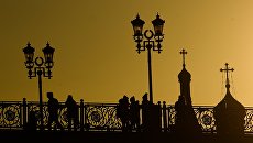 Прохожие на Патриаршем мосту в Москве Прохожие на Патриаршем мосту в Москве