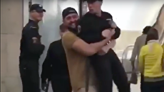 Стоп-кадр с видео, где мужчина несет сотрудника Росгвардии в руках по вестибюлю станции Сухаревская Стоп-кадр с видео, где мужчина несет сотрудника Росгвардии в руках по вестибюлю станции Сухаревская