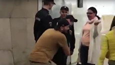 Стоп-кадр с видео, где мужчина несет сотрудника Росгвардии в руках по вестибюлю станции Сухаревская Стоп-кадр с видео, где мужчина несет сотрудника Росгвардии в руках по вестибюлю станции Сухаревская