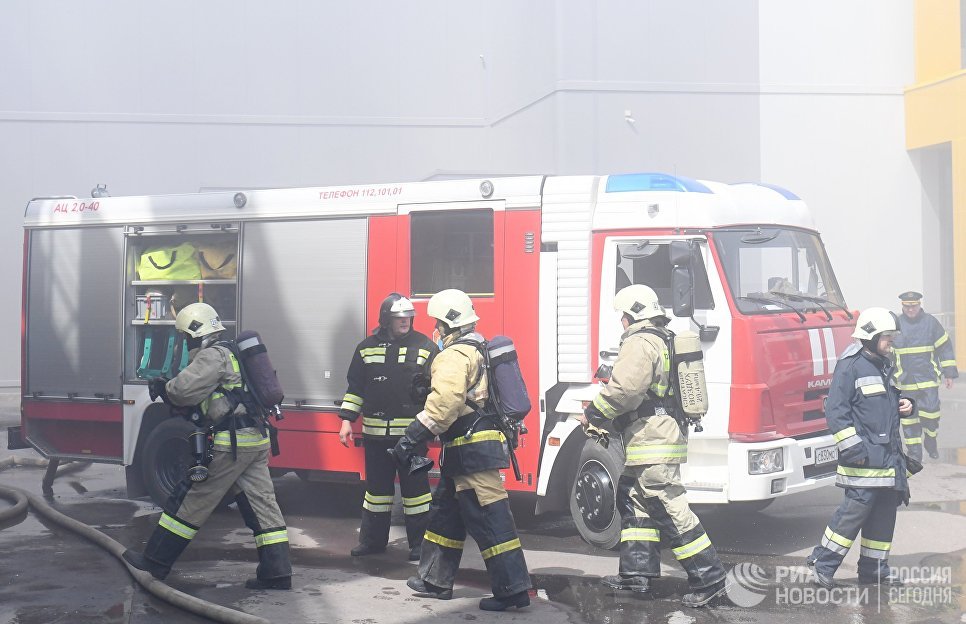 Сотрудники МЧС и пожарная техника перед зданием торгового центра Порт в Казани, где произошло возгорание