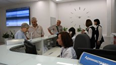 Посетители у регистратуры поликлиники Посетители у регистратуры поликлиники