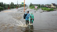 Местные жители на затопленной в результате паводка улице в Чите. Архивное фото Местные жители на затопленной в результате паводка улице в Чите. Архивное фото
