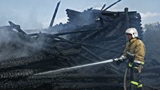 Сотрудник противопожарной службы у сгоревшего здания церкви Успения Божией Матери в Кондопоге в Карелии. Архивное фото Сотрудник противопожарной службы у сгоревшего здания церкви Успения Божией Матери в Кондопоге в Карелии. Архивное фото