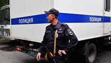 Полицейский у служебного автомобиля. Архивное фото Полицейский у служебного автомобиля. Архивное фото