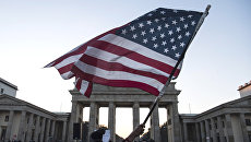 Флаг США во время акции протеста у Бранденбургских ворот в Берлине. Архивное фото Флаг США во время акции протеста у Бранденбургских ворот в Берлине. Архивное фото