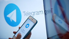 Логотип мессенджера Telegram на экране монитора и телефона Логотип мессенджера Telegram на экране монитора и телефона