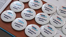 Памятные значки на столе в единый день голосования на избирательном участке в Москве Памятные значки на столе в единый день голосования на избирательном участке в Москве