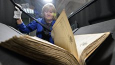Сотрудница сканирует архивные документы Сотрудница сканирует архивные документы