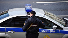 Сотрудник Росгвардии у полицейской машины. Архивное фото Сотрудник Росгвардии у полицейской машины. Архивное фото