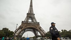 Сотрудник полиции возле Эйфелевой башни в Париже Сотрудник полиции возле Эйфелевой башни в Париже